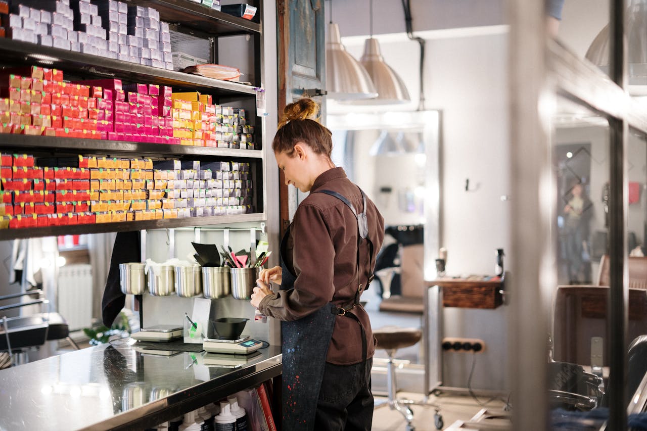 about-img Hairdresser organizing hair color products in a modern salon.